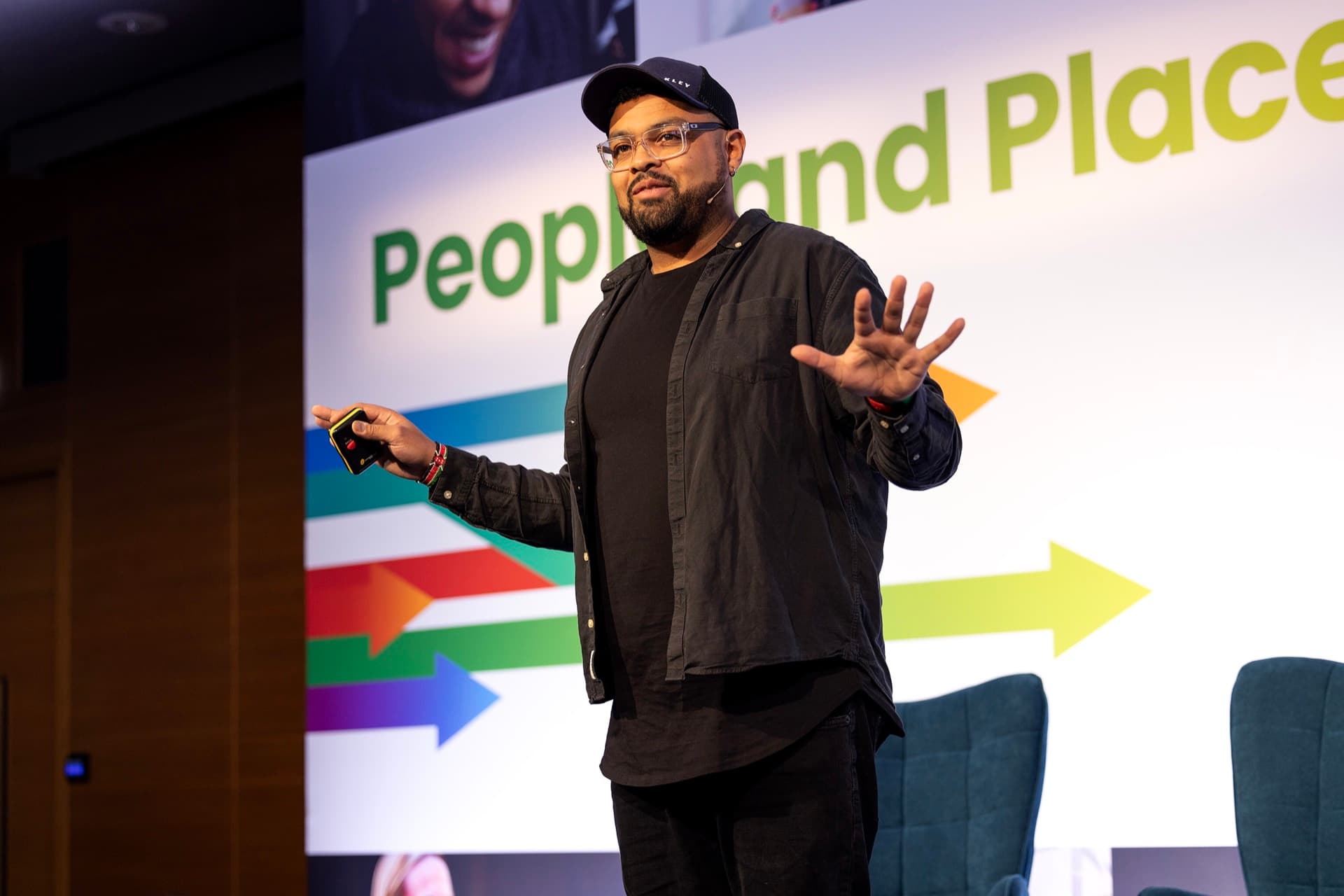 Tom keynoting in front of a People and Places stage screen